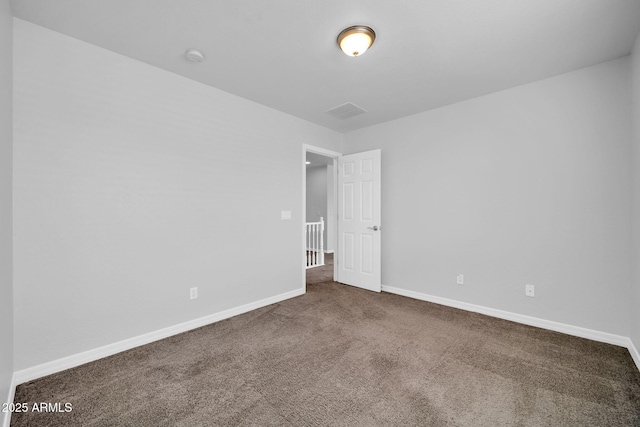 carpeted empty room with visible vents and baseboards