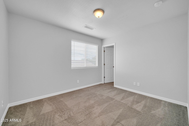 spare room with visible vents, baseboards, and carpet flooring