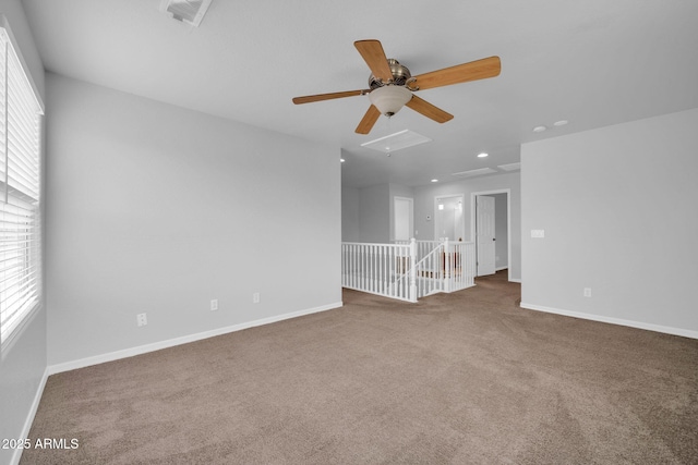 carpeted spare room featuring visible vents, baseboards, and a ceiling fan