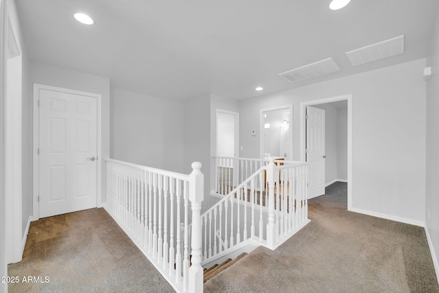 hall with recessed lighting, an upstairs landing, visible vents, and carpet floors