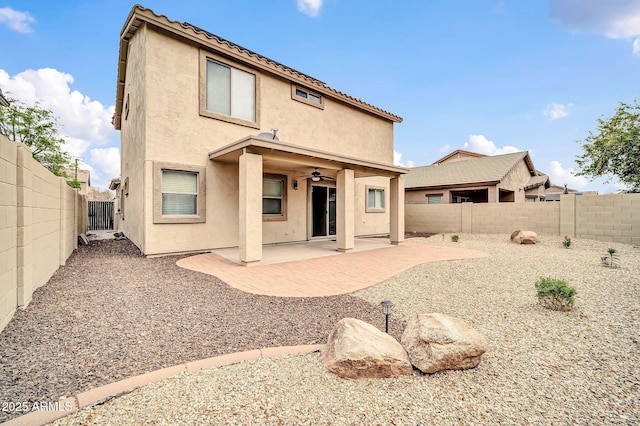 rear view of property featuring stucco siding, a patio, a fenced backyard, and ceiling fan