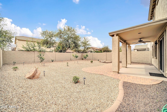 view of yard featuring a fenced backyard, a patio, and ceiling fan