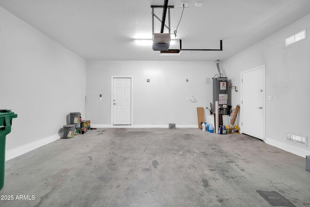 garage featuring water heater, visible vents, a garage door opener, and baseboards