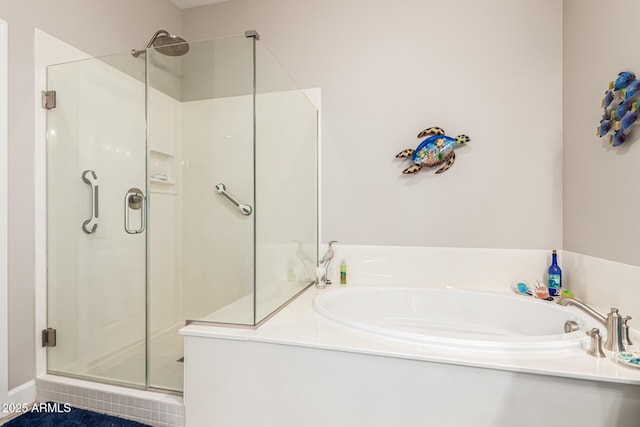 bathroom with a stall shower and a garden tub