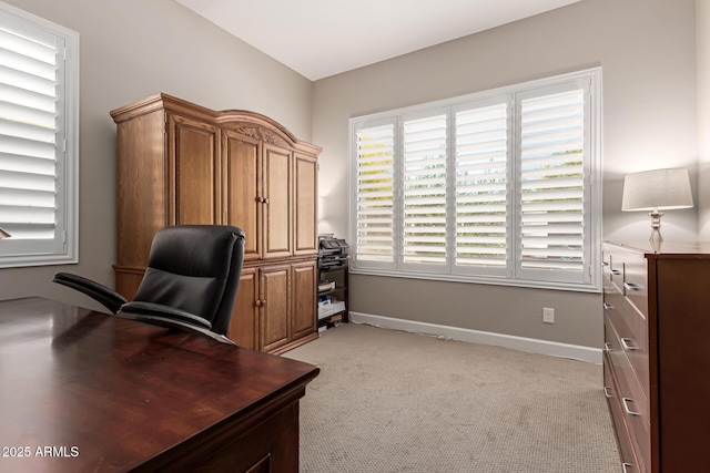 home office with baseboards and light colored carpet