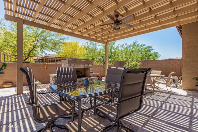view of patio featuring ceiling fan, a pergola, an outdoor stone fireplace, outdoor dining area, and a fenced backyard