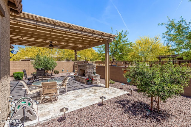 view of patio / terrace featuring a fenced backyard and an outdoor stone fireplace