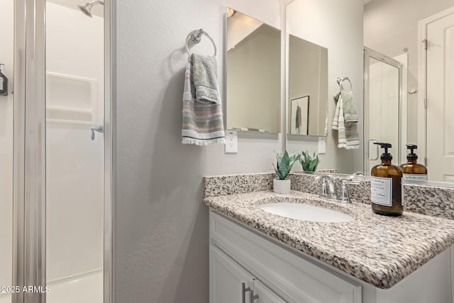 bathroom featuring a shower stall and vanity