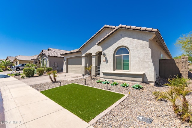 mediterranean / spanish-style home featuring a tiled roof, a garage, stucco siding, and driveway