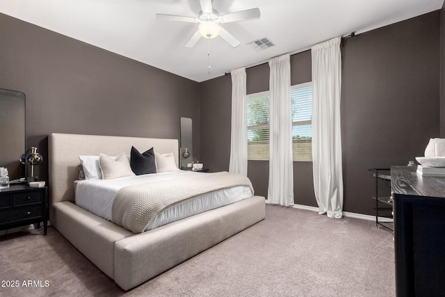 carpeted bedroom with visible vents, baseboards, and ceiling fan