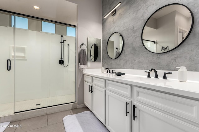 bathroom with a sink, tile patterned flooring, double vanity, and a stall shower