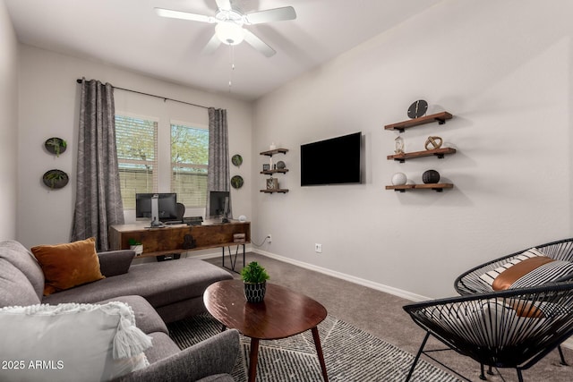 living area featuring carpet floors, baseboards, and a ceiling fan