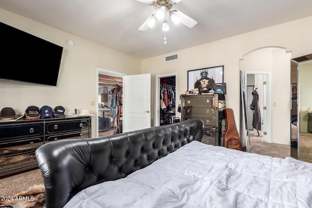 bedroom featuring ceiling fan, a walk in closet, carpet flooring, and a closet