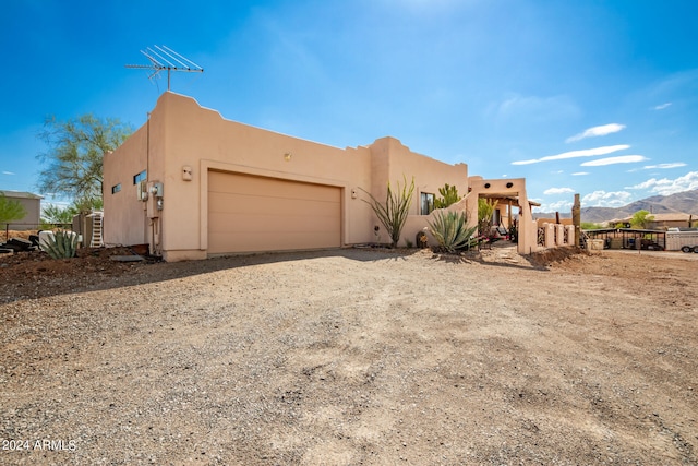 view of front of property with a garage and a mountain view