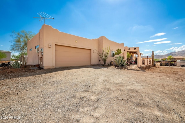 adobe home with a garage and a mountain view