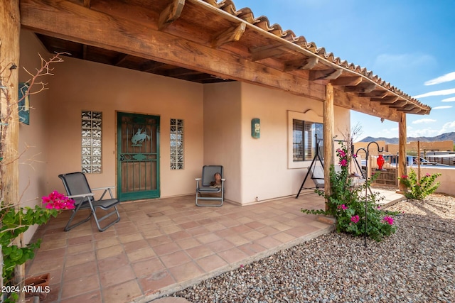 entrance to property featuring a mountain view and a patio