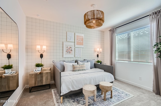 bedroom featuring light colored carpet and tile walls