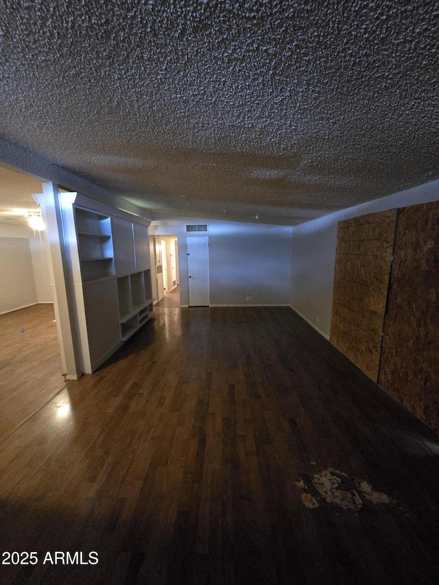 empty room featuring dark wood-style floors and a textured ceiling