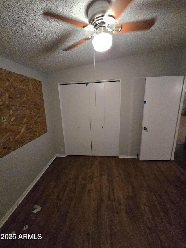 unfurnished bedroom featuring baseboards, ceiling fan, wood finished floors, a textured ceiling, and a closet