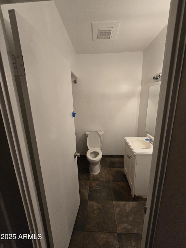 bathroom with visible vents, vanity, and toilet