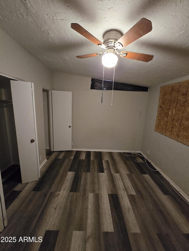 unfurnished bedroom featuring lofted ceiling, a closet, a ceiling fan, a textured ceiling, and wood finished floors