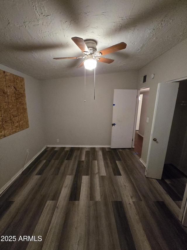 spare room featuring a ceiling fan, a textured ceiling, baseboards, and wood finished floors