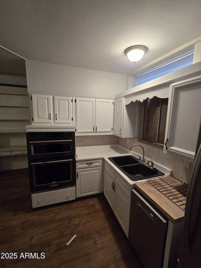 kitchen with black appliances, dark wood-type flooring, a sink, and white cabinetry