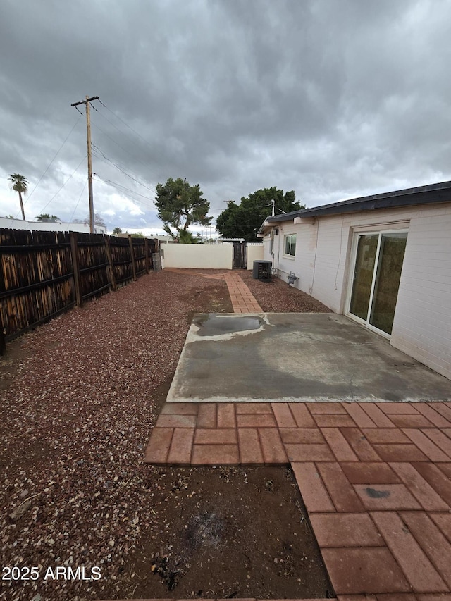 view of yard featuring central AC, a patio area, and a fenced backyard