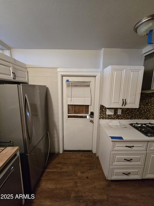 kitchen featuring appliances with stainless steel finishes, tasteful backsplash, white cabinets, and dark wood-style floors