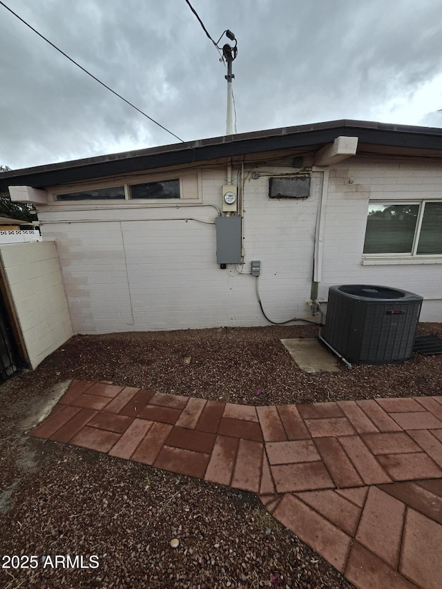 view of home's exterior featuring entry steps, central AC, and brick siding