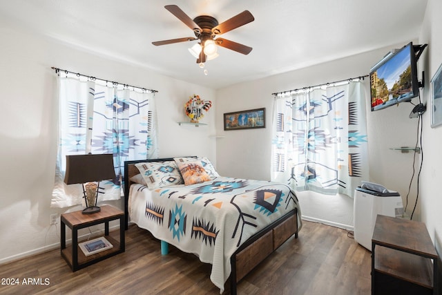 bedroom with ceiling fan, dark hardwood / wood-style flooring, and multiple windows