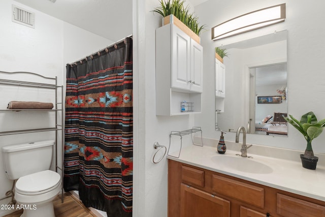 bathroom featuring a shower with shower curtain, vanity, and toilet