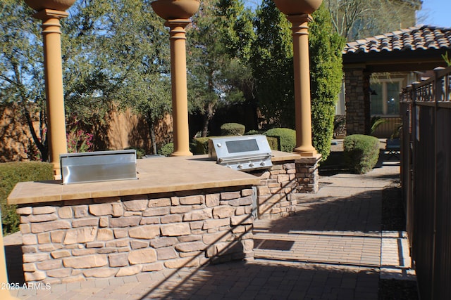 view of patio / terrace featuring exterior kitchen and a grill