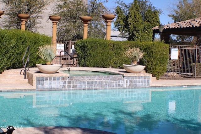 view of swimming pool with a hot tub