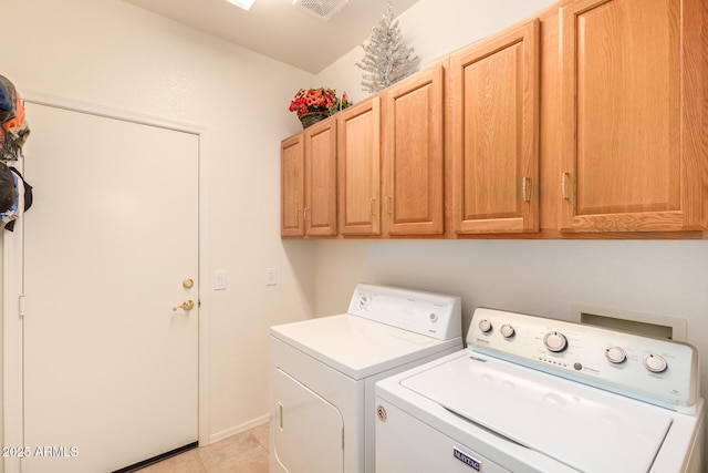 washroom featuring cabinets, light tile patterned floors, and washing machine and dryer