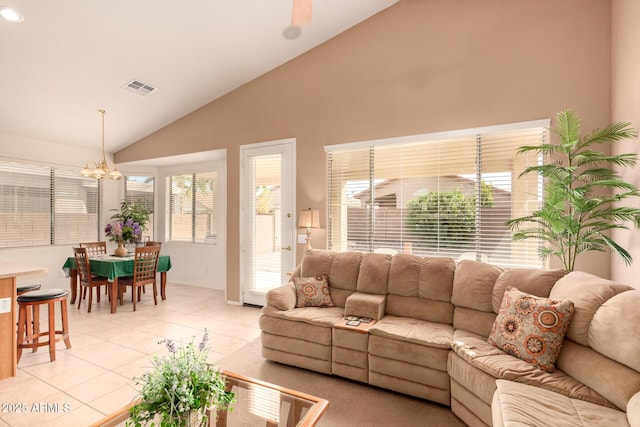 living room with lofted ceiling, light tile patterned floors, and an inviting chandelier