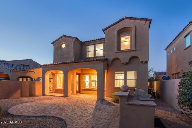 9305 E Canyon View Rd, Scottsdale, AZ 85255 - rear view of house featuring a tiled roof, stucco siding, a fenced backyard, a patio area, and an outdoor kitchen