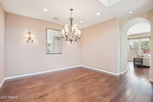 9305 E Canyon View Rd, Scottsdale, AZ 85255 - empty room featuring baseboards, a chandelier, recessed lighting, wood finished floors, and arched walkways