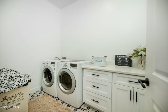 washroom with baseboards, cabinet space, and washing machine and dryer