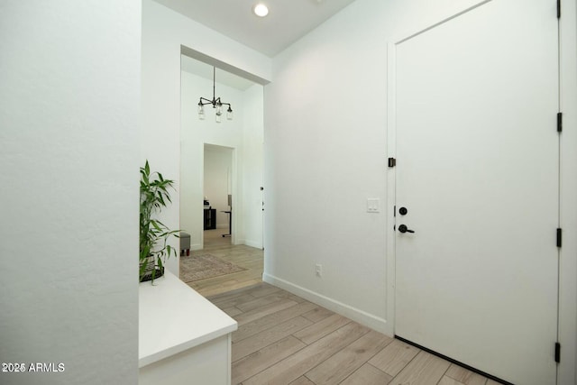 foyer entrance featuring baseboards and light wood finished floors