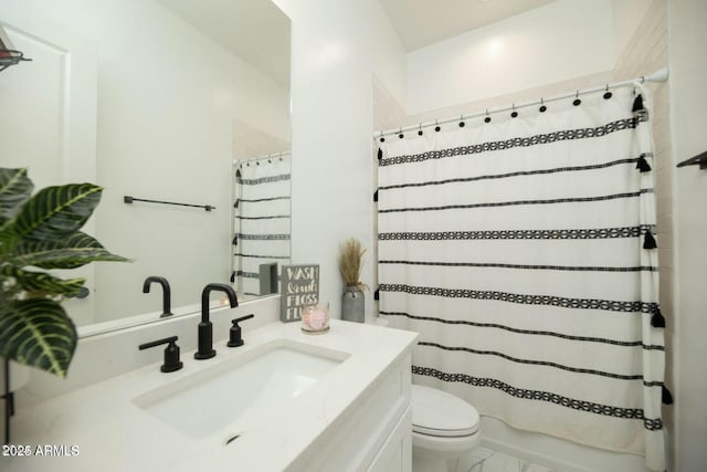 bathroom with toilet, marble finish floor, and vanity