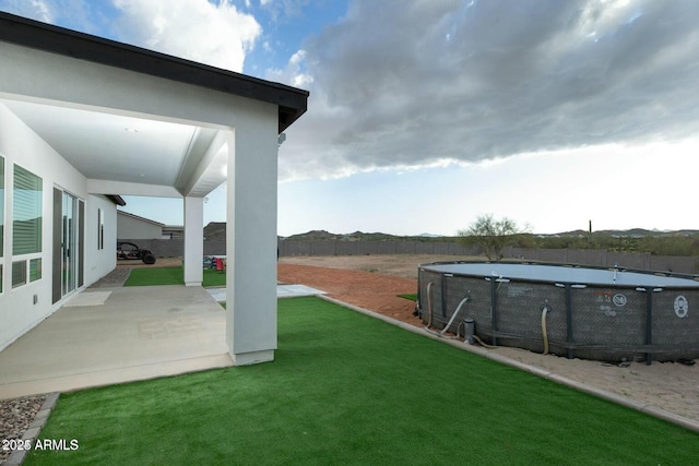 view of yard featuring a fenced in pool, a patio, and fence