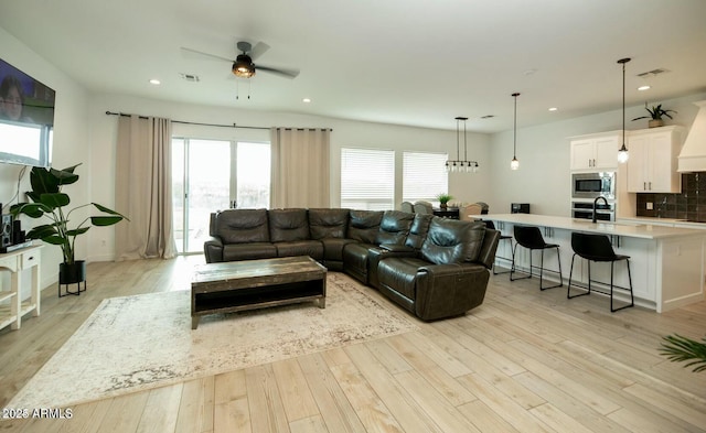 living room featuring light wood-style flooring, recessed lighting, and visible vents