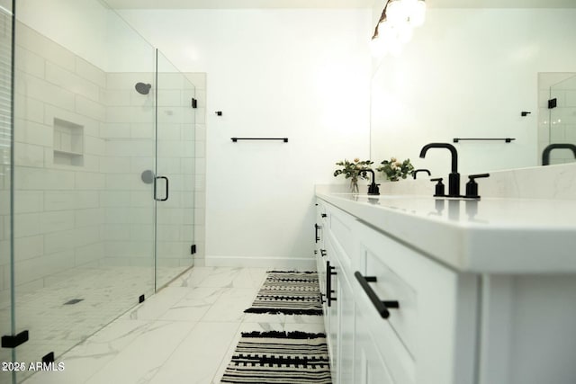 full bath with baseboards, double vanity, a stall shower, a sink, and marble finish floor