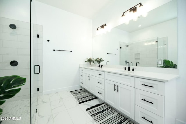 full bath featuring marble finish floor, a sink, a shower stall, double vanity, and baseboards