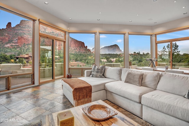 sunroom featuring recessed lighting, visible vents, stone tile floors, and a mountain view