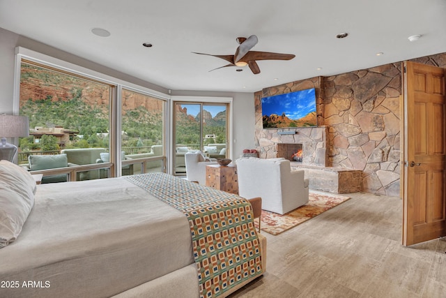 bedroom with ceiling fan and a fireplace