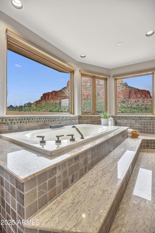 bathroom featuring a bath and recessed lighting