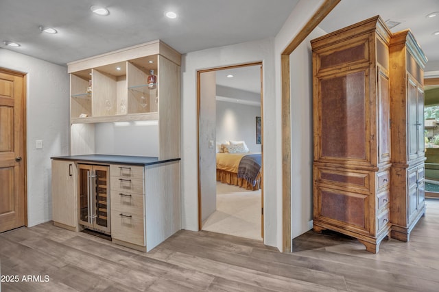 bar with light wood-style flooring, a dry bar, beverage cooler, and recessed lighting