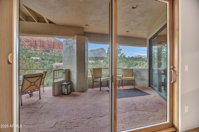 entryway featuring a healthy amount of sunlight, a mountain view, and carpet
